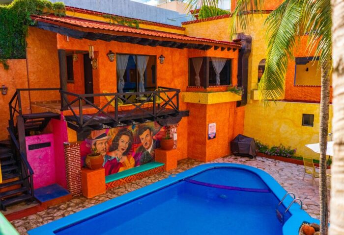 Hotel Hacienda Maria Bonita's courtyard view. Colorful gay-friendly hotel with a pool, mural, and balcony. Ideal for gay men travel advice.