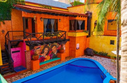 Hotel Hacienda Maria Bonita's courtyard view. Colorful gay-friendly hotel with a pool, mural, and balcony. Ideal for gay men travel advice.