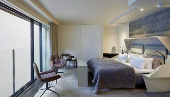 Hotel Herman K by Brøchner Hotels bedroom. Gay-friendly hotel room with a king bed, chairs, and a large window. Modern design for gay travelers.