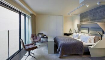 Hotel Herman K by Brøchner Hotels bedroom. Gay-friendly hotel room with a king bed, chairs, and a large window. Modern design for gay travelers.