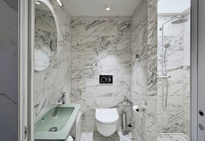 Hotel Herman K by Brøchner Hotels bathroom. Marble tiles, sink, toilet, and shower. Gay-friendly hotel for gay men travel.