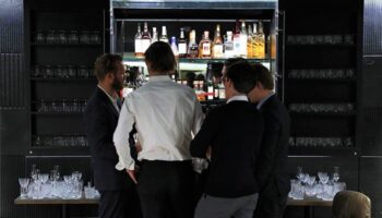 Hotel Herman K by Brøchner Hotels bar. Gay-friendly hotel bar with men gathered around drinks. Upscale travel experience.