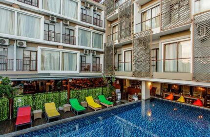 Horison Seminyak Bali hotel view. Poolside loungers, modern building design. Gay-friendly hotel in Bali, perfect for gay travel.