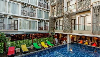 Horison Seminyak Bali hotel view. Poolside loungers, modern building design. Gay-friendly hotel in Bali, perfect for gay travel.
