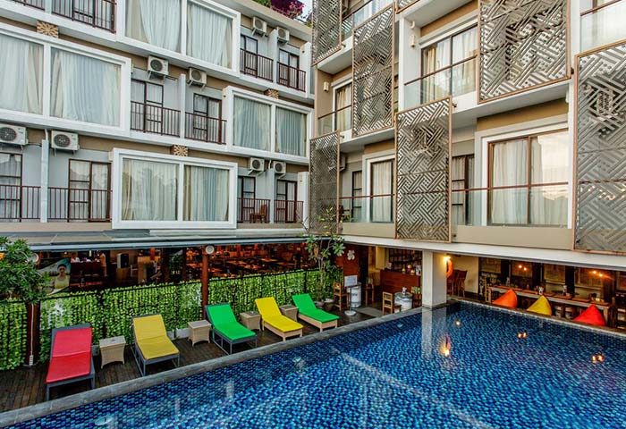 Horison Seminyak Bali hotel view. Poolside loungers, modern building design. Gay-friendly hotel in Bali, perfect for gay travel.
