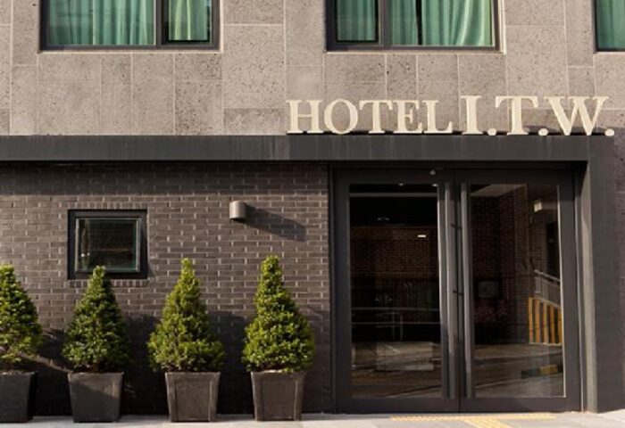 Hotel ITW, a gay-friendly hotel. Facade view of the entrance, featuring modern architecture and potted plants. Ideal for gay men's travel.
