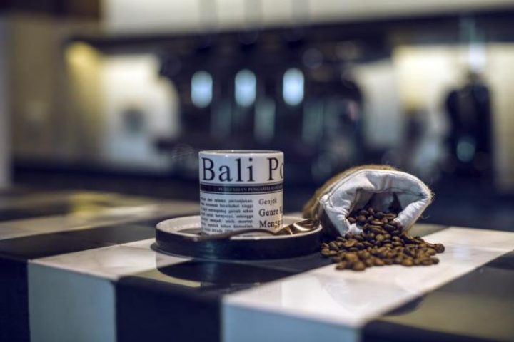 Coffee beans and a Bali-themed cup at Hotel Indigo Bali Seminyak Beach, a gay-friendly hotel. Enjoy coffee during your gay travel in Bali.