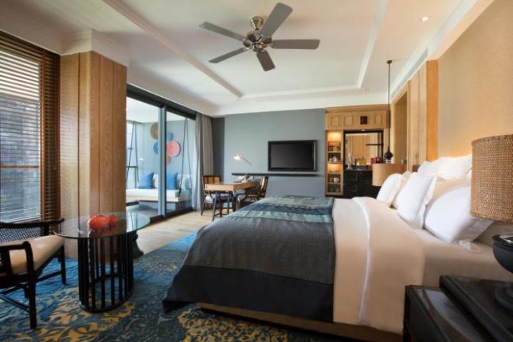 Hotel Indigo Bali Seminyak Beach room. Gay-friendly hotel with bed, TV, desk, and balcony. Luxury travel for LGBT visitors in Bali.