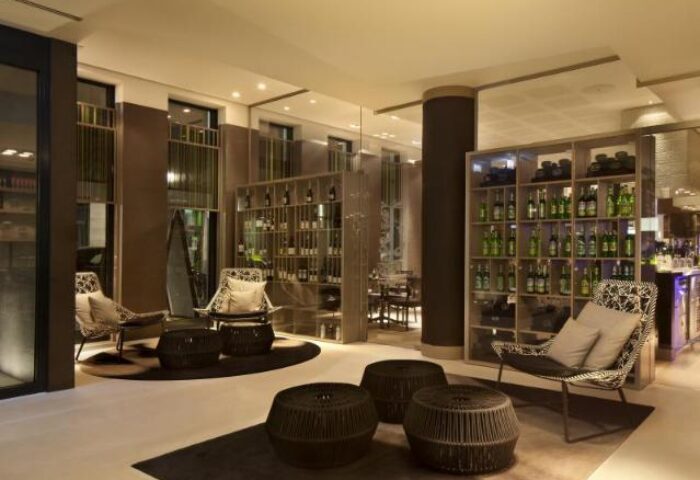 Hotel Indigo Berlin-Alexanderplatz's stylish lounge area. A gay-friendly hotel with a bar, seating, and wine shelves. Ideal for LGBTQ+ travelers.
