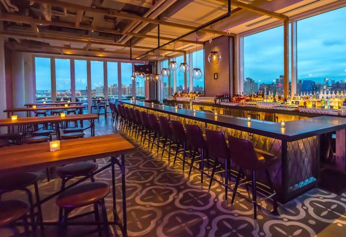 Hotel Indigo Lower East Side's gay-friendly rooftop bar. City views, bar stools, tables, and patterned floor. Great for gay travelers.