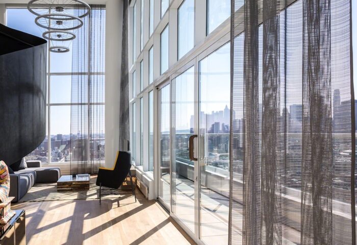 Hotel Indigo Lower East Side gay-friendly hotel room with city view. Modern design, floor-to-ceiling windows, and unique decor.