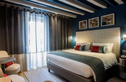 Hotel Indigo Milan Corso Monforte room. Gay-friendly hotel with bed, chairs, and stylish decor. Great for gay travel.
