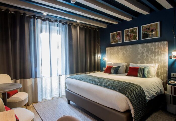 Hotel Indigo Milan Corso Monforte room. Gay-friendly hotel with bed, chairs, and stylish decor. Great for gay travel.