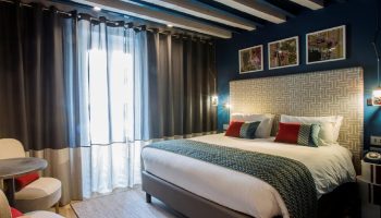 Hotel Indigo Milan Corso Monforte room. Gay-friendly hotel with bed, chairs, and stylish decor. Great for gay travel.