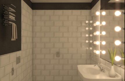 Hotel Indigo Milan Corso Monforte gay-friendly bathroom. Bright mirror lights, white tiles, and patterned floor. Modern design.