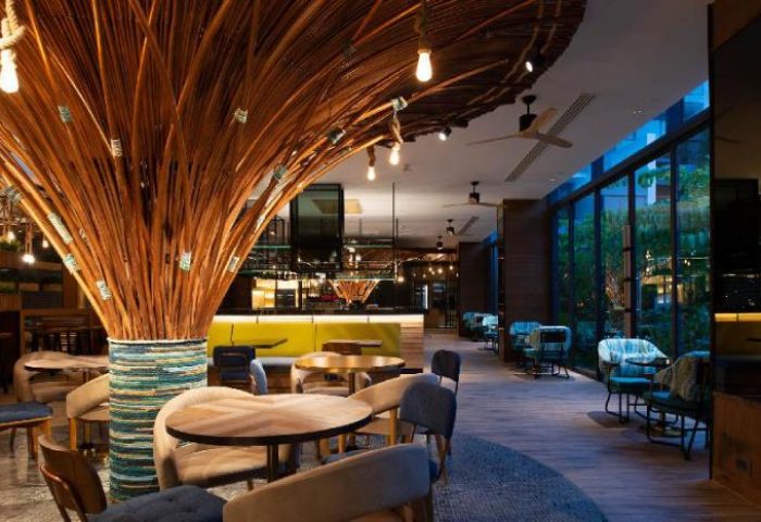 Hotel Indigo Phuket Patong's stylish lounge area. Gay-friendly hotel with unique decor, featuring a striking branch arrangement and cozy seating.
