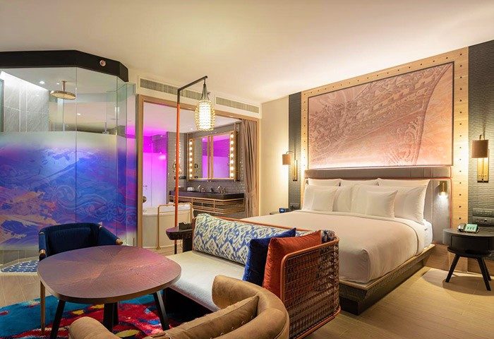 Hotel Indigo Phuket Patong gay-friendly room. Modern decor, king bed, colorful seating area, and bathroom with vibrant lighting.