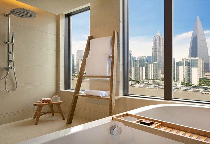 Hotel Indigo Shanghai On The Bund: Gay-friendly hotel bathroom with city view. Bathtub, shower, towels, and scenic Shanghai skyline.