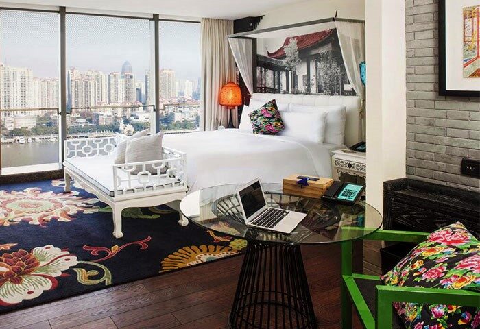 Hotel Indigo Shanghai On The Bund room with city view. Gay-friendly hotel with modern design, laptop on table, and stylish decor.