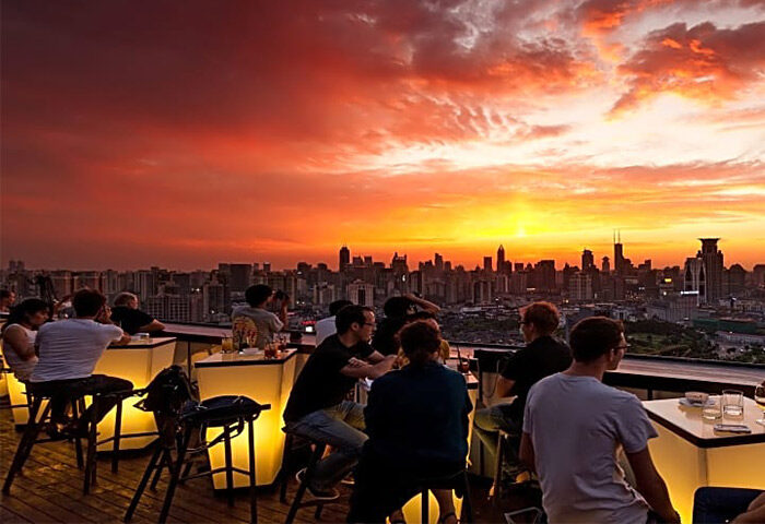 Hotel Indigo Shanghai On The Bund gay-friendly hotel rooftop bar at sunset. Shanghai skyline view from the bar.