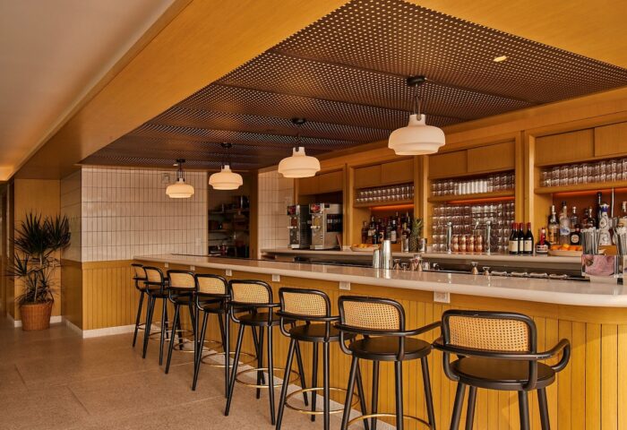 Hotel Indigo Williamsburg Brooklyn bar. Stylish interior with bar stools, liquor bottles, and pendant lights. Gay-friendly hotel.