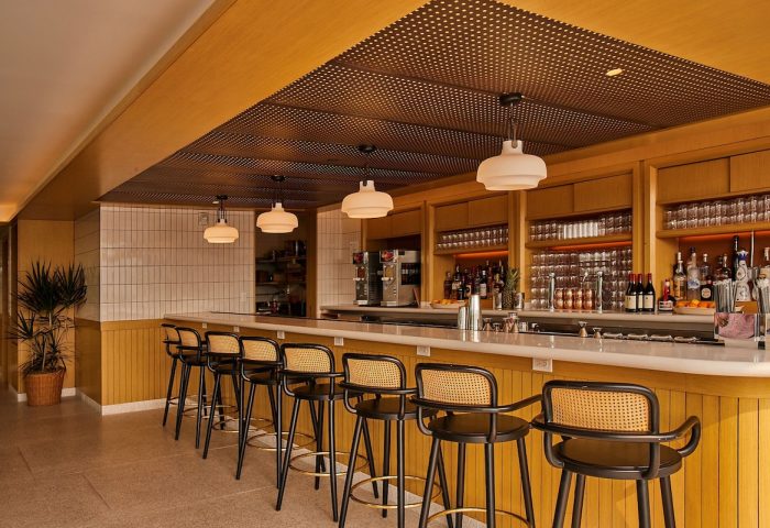 Hotel Indigo Williamsburg Brooklyn bar. Stylish interior with bar stools, liquor bottles, and pendant lights. Gay-friendly hotel.