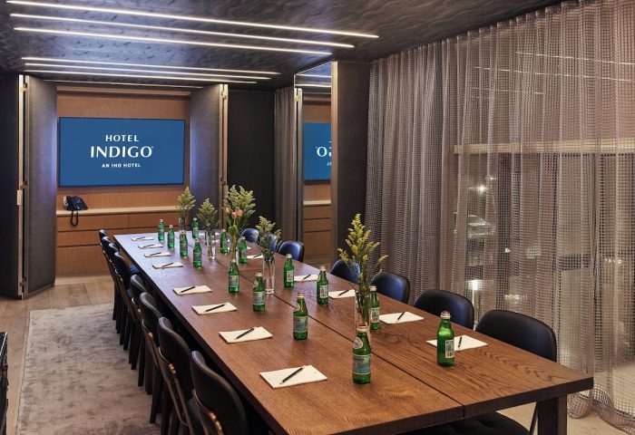 Hotel Indigo Williamsburg Brooklyn meeting room. Long table, chairs, screen with hotel logo. Gay-friendly hotel for gay men travel.