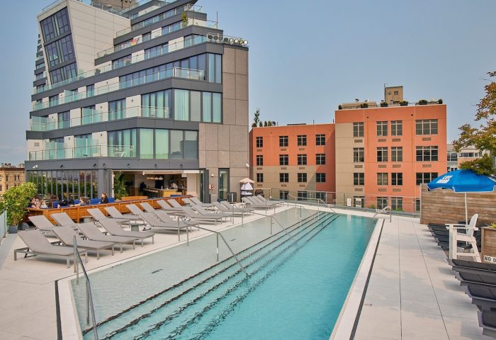 Rooftop pool at Hotel Indigo Williamsburg, Brooklyn. Gay-friendly hotel with lounge chairs, bar, and city views. Perfect for gay men's travel.