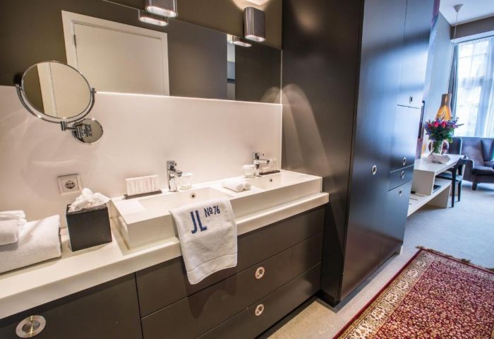 Hotel JL No76's gay-friendly bathroom. Double sinks, modern design, & a view into the room. Ideal for gay men seeking stylish Amsterdam lodging.