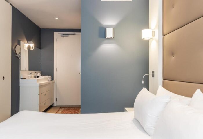 Hotel JL No76 gay-friendly hotel room. Modern design with a bed, pillows, headboard, and bathroom area. Interior of this gay hotel in Amsterdam.