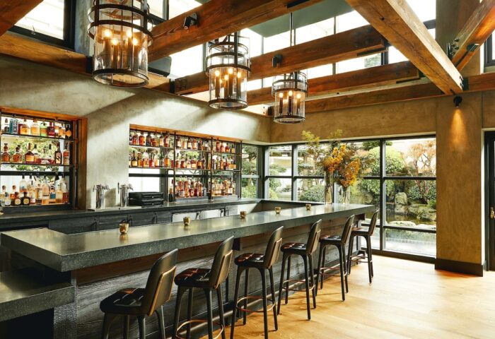 Hotel Kabuki bar area, part of JdV by Hyatt, a gay-friendly hotel. The bar offers a wide selection of drinks and a view of the garden.