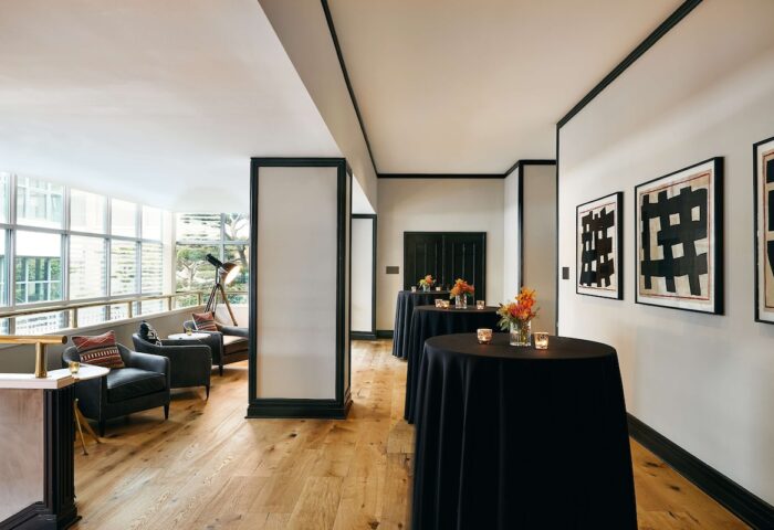 Hotel Kabuki, part of Jdv by Hyatt, a gay-friendly hotel. Lounge area with black tables, armchairs, and telescope. Stylish, modern design.