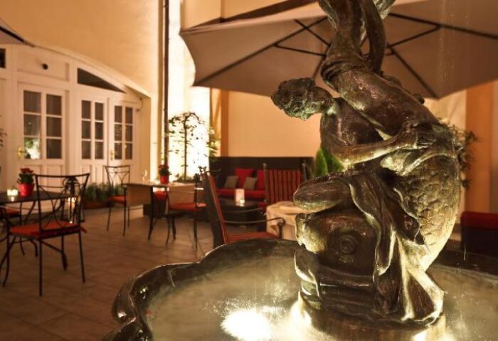 Hotel Leonardo Prague's courtyard with a fountain. This gay-friendly, pet-friendly hotel offers a relaxing outdoor space for guests.