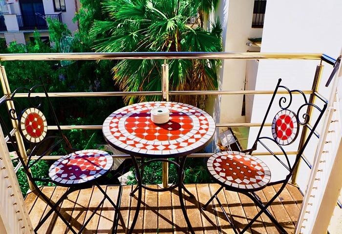 Hotel Liberty Sitges balcony view. Gay-friendly hotel with mosaic table and chairs. Relaxing outdoor space for gay travelers.