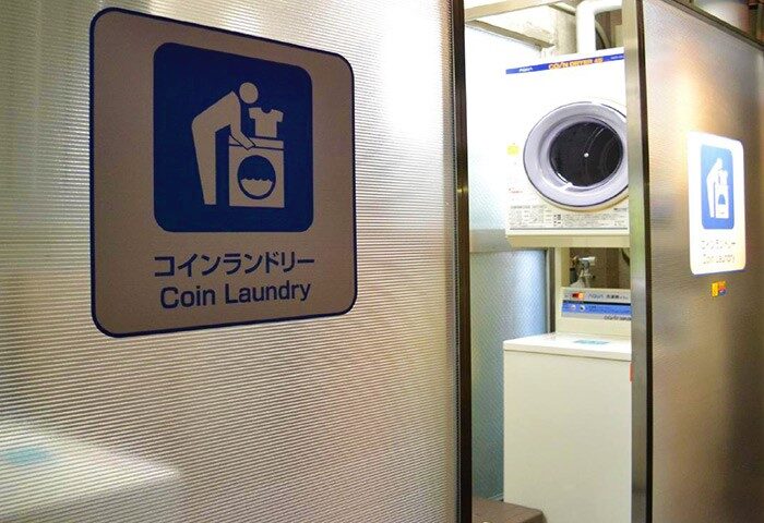 Hotel Listel Shinjuku's coin laundry. Signage in English and Japanese. Gay-friendly hotel amenity for travelers to Tokyo, Japan.
