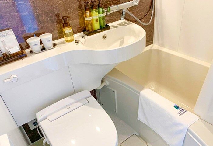 Hotel Livemax Shinjuku-Kabukicho bathroom. Sink, toilet, and tub in a compact space. Ideal for gay travelers seeking comfort in Shinjuku, Tokyo.