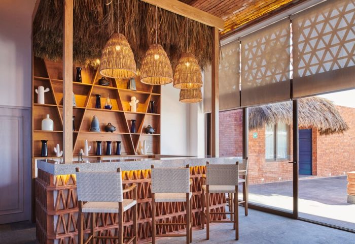 Hotel Luxury Patio Azul bar area. Gay-friendly hotel with stylish decor, woven pendant lights, and unique shelving. Ideal for gay men's travel.