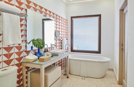 Bathroom at Hotel Luxury Patio Azul, a gay-friendly hotel. Features a modern sink, bathtub, and stylish tile work. Ideal for gay travel.