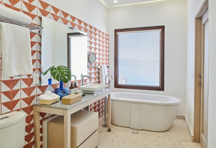 Bathroom at Hotel Luxury Patio Azul, a gay-friendly hotel. Features a modern sink, bathtub, and stylish tile work. Ideal for gay travel.
