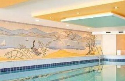 Hotel Lyskirchen's indoor pool. A gay-friendly hotel with a swimming pool and a mural of a lake with mountains and a bird. Cologne, Germany.
