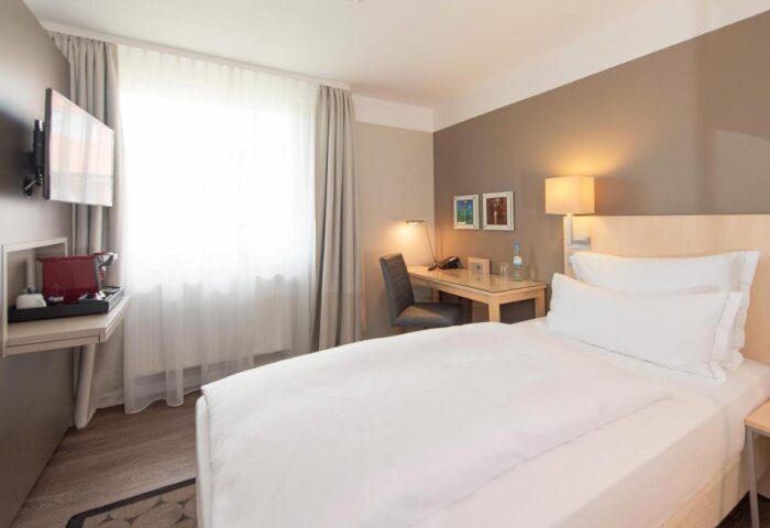 Hotel Lyskirchen gay-friendly room. Modern interior with bed, desk, TV, and coffee maker. Ideal for gay men's travel in Cologne.