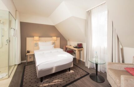 Hotel Lyskirchen gay-friendly hotel room with single bed, desk, shower, and chair. Modern design for gay travelers.