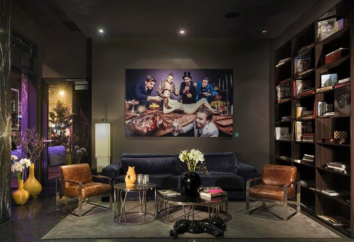 Hotel MANI by AMANO interior. Gay-friendly hotel lounge area with modern furniture, art, and bookshelves. Stylish, inviting space.