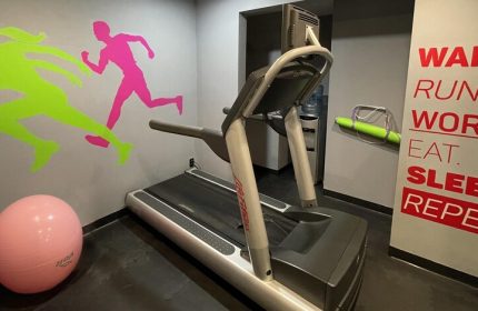 Hotel MX mas reforma gay-friendly gym. Treadmill, exercise ball, and running figure decals. Wake, Run, Work, Eat, Sleep, Repeat quote.