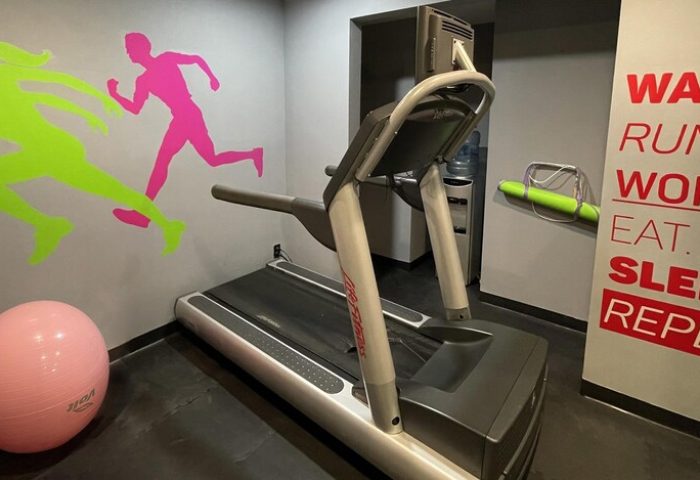 Hotel MX mas reforma gay-friendly gym. Treadmill, exercise ball, and running figure decals. Wake, Run, Work, Eat, Sleep, Repeat quote.
