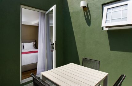 Hotel MX mas reforma gay-friendly room. Balcony with table and chairs, open door to bedroom. Modern design for gay travelers.
