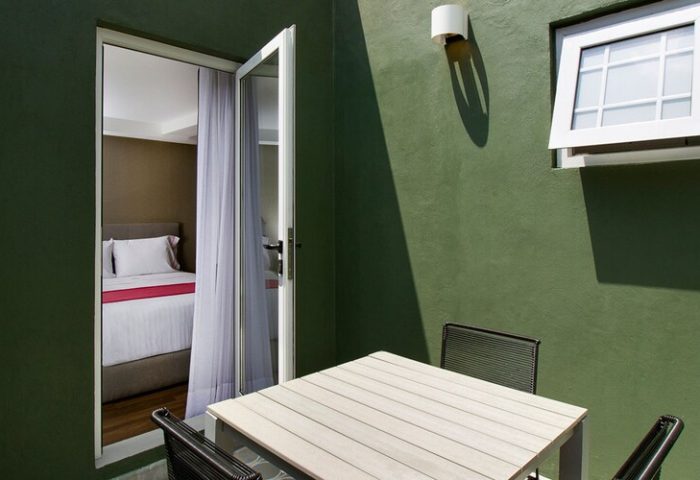 Hotel MX mas reforma gay-friendly room. Balcony with table and chairs, open door to bedroom. Modern design for gay travelers.