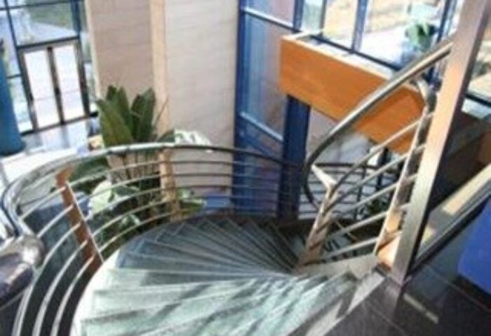 Spiral staircase at Hotel Madeira Centro, a gay-friendly hotel. Interior design detail for gay men's travel. Modern architecture.