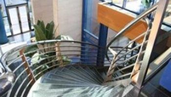 Spiral staircase at Hotel Madeira Centro, a gay-friendly hotel. Interior design detail for gay men's travel. Modern architecture.