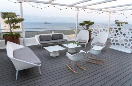 Hotel Madeira Centro's gay-friendly rooftop terrace. White modern furniture, ocean view. Perfect for gay travelers seeking relaxation.